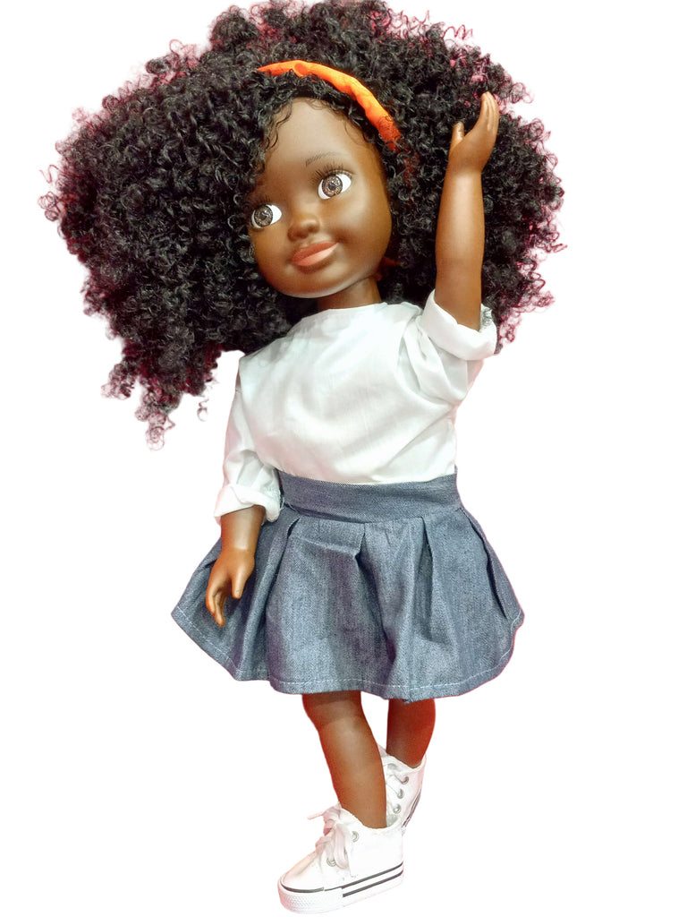 A black doll with a red headband, wearing a white blouse and blue denim skirt, posed on a red couch.
